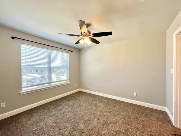 an empty room with a window and a fan