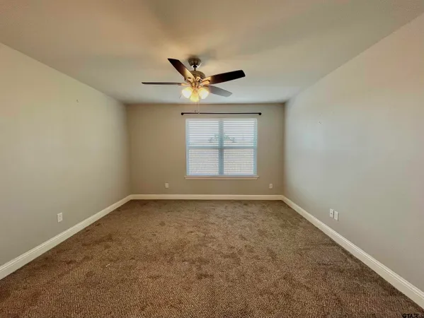 an empty room with a window and a ceiling fan