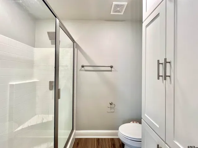 a bathroom with a toilet and a shower