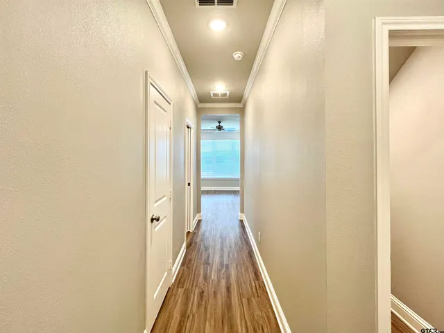 a view of a hallway with wooden floor