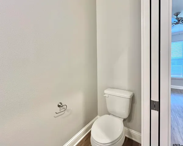 a white toilet sitting next to a white wall