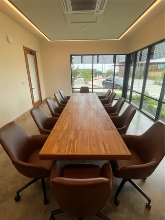 a outdoor space with lots of tables a large window and chairs
