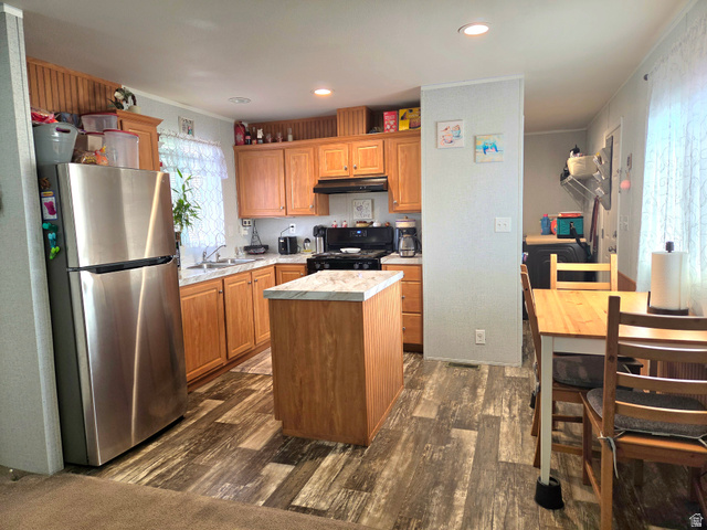 597 North State Street, Unit 67 Orem, UT 84057 - Photo 11 of 23 Kitchen with freestanding refrigerator, light countertops, dark wood finished floors, a center island, and ornamental molding