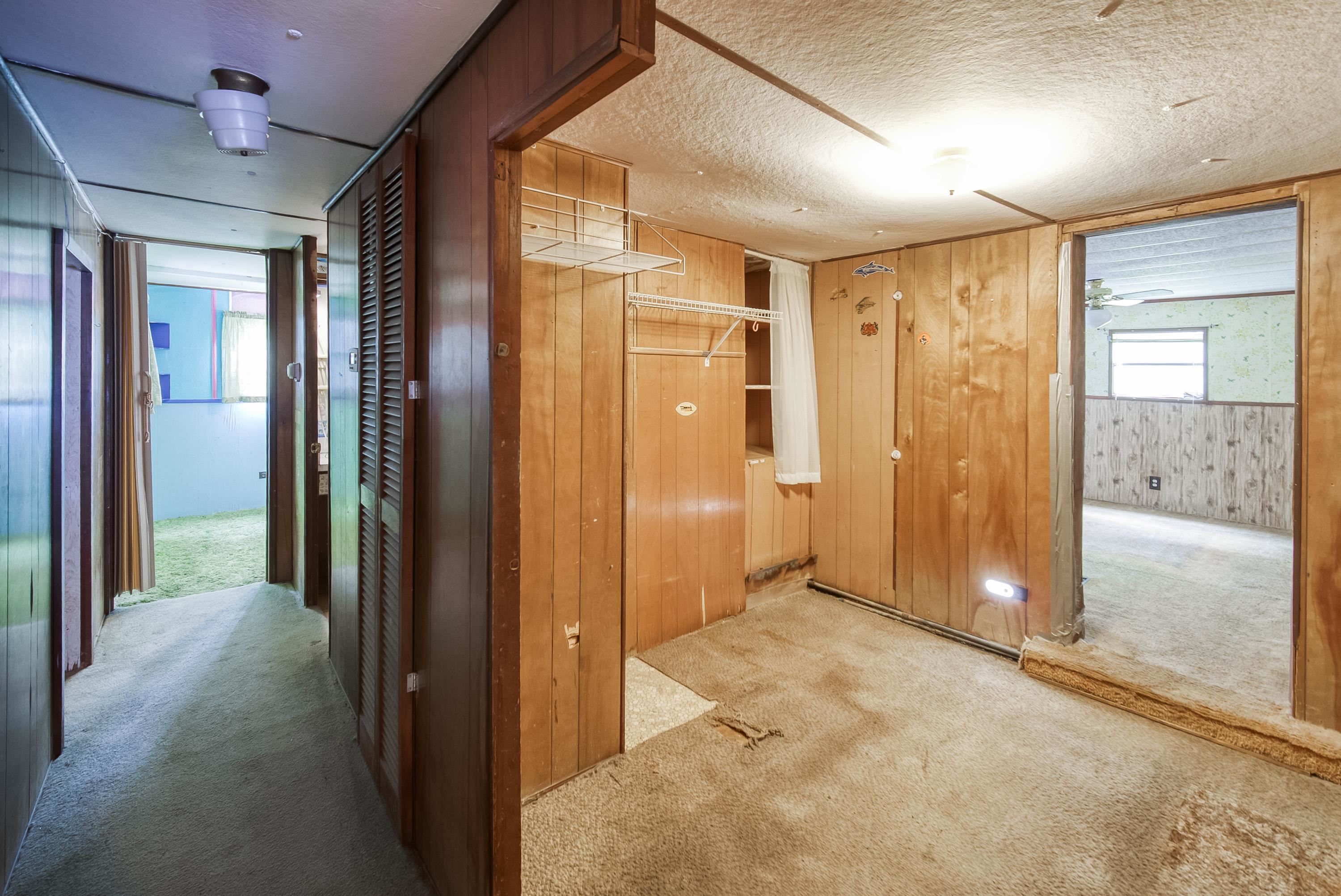 2785 Stratton Boulevard St. Augustine, FL 32084 - Photo 22 of 25 Hallway with carpet, wooden walls, and a textured ceiling