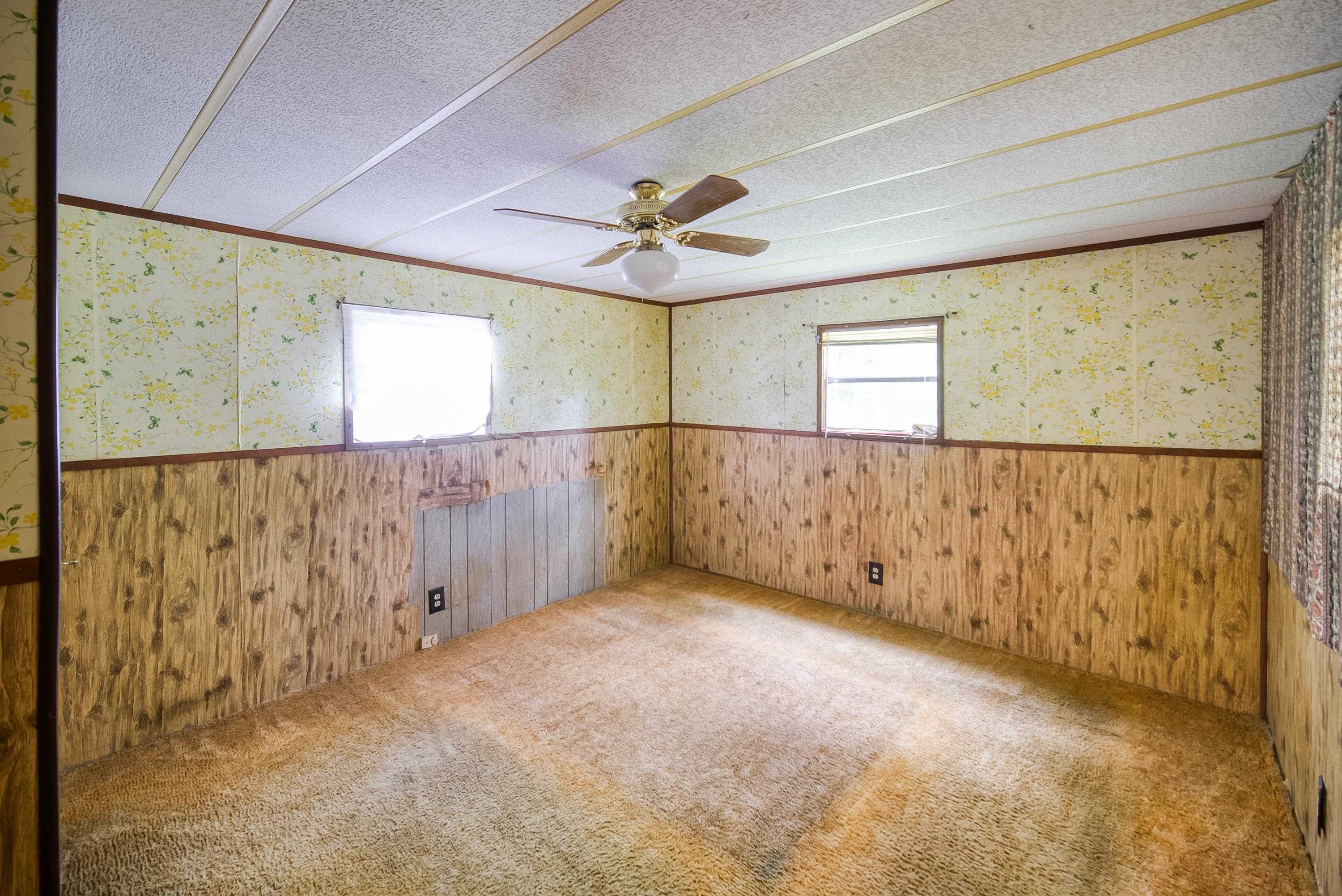 2785 Stratton Boulevard St. Augustine, FL 32084 - Photo 23 of 25 Spare room with a textured ceiling, carpet, wallpapered walls, wainscoting, and wooden walls