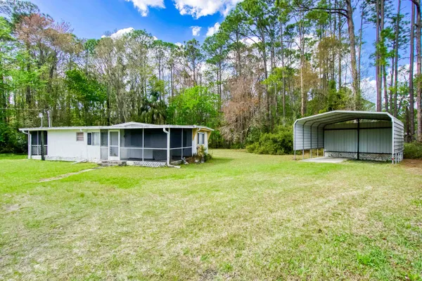 a backyard of a house with a garden and barbeque oven