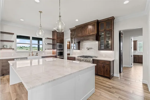 a large white kitchen island cabinets a refrigerator and a wooden floors