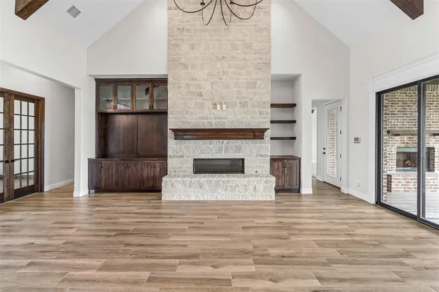 a view of a livingroom with wooden floor and a fireplace