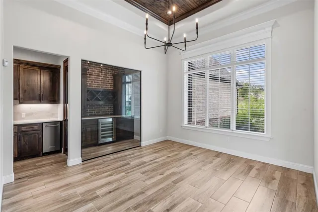 a view of an empty room with a kitchen and wooden floor