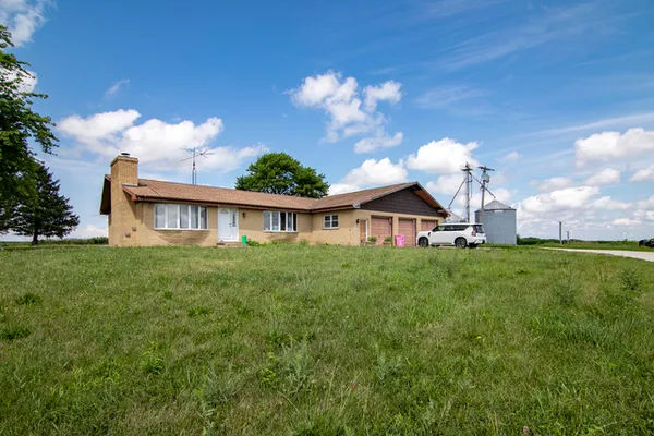 a view of a house with a big yard plants and large trees