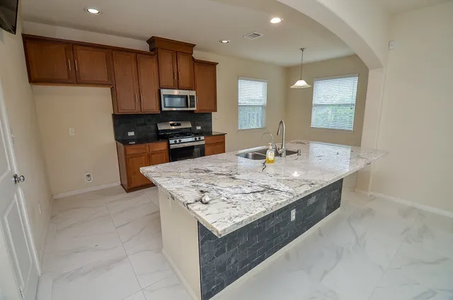 a kitchen with stainless steel appliances granite countertop a sink stove and refrigerator