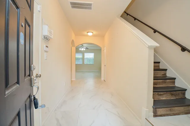 a view of a hallway with wooden floor and entryway