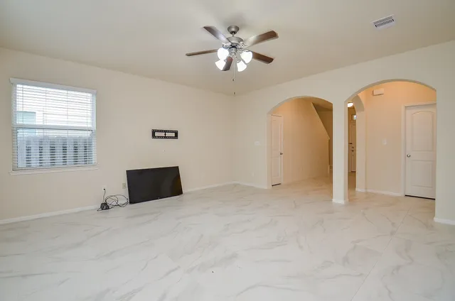 a view of a livingroom with a ceiling fan and window