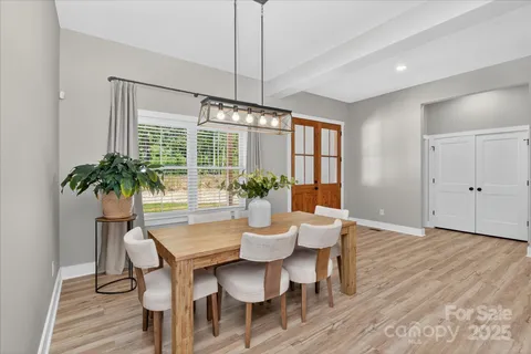a dining room with furniture a chandelier and wooden floor