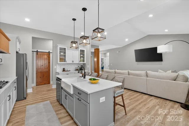 a kitchen with stainless steel appliances granite countertop a sink dishwasher a refrigerator and a stove