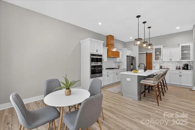 a dining room with furniture a chandelier and wooden floor