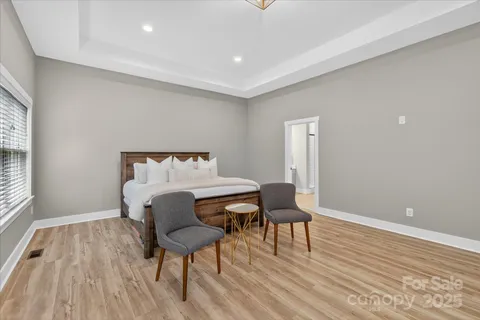 a bedroom with a bed and wooden floor