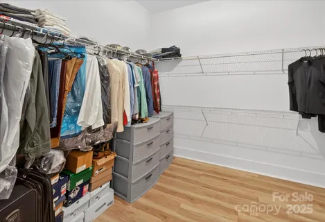 a view of walk in closet with clothes and shoes