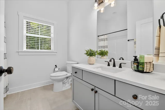a bathroom with a granite countertop sink mirror and toilet