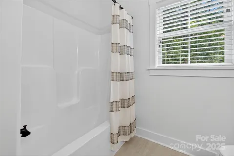 a bathroom with a window and a shower