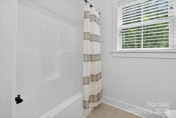 a bathroom with a window and a shower