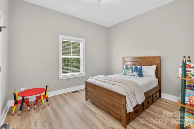 a large bed sitting in a bedroom next to a window
