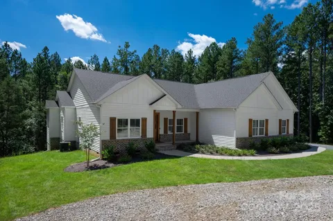 a view of a house with a yard and potted plants