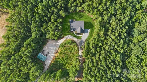 a aerial view of a house with a yard and fountain