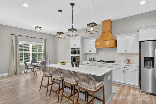 a view of a dining room and livingroom with furniture wooden floor a chandelier