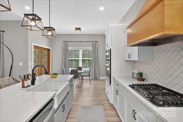a kitchen with stove a sink and cabinets