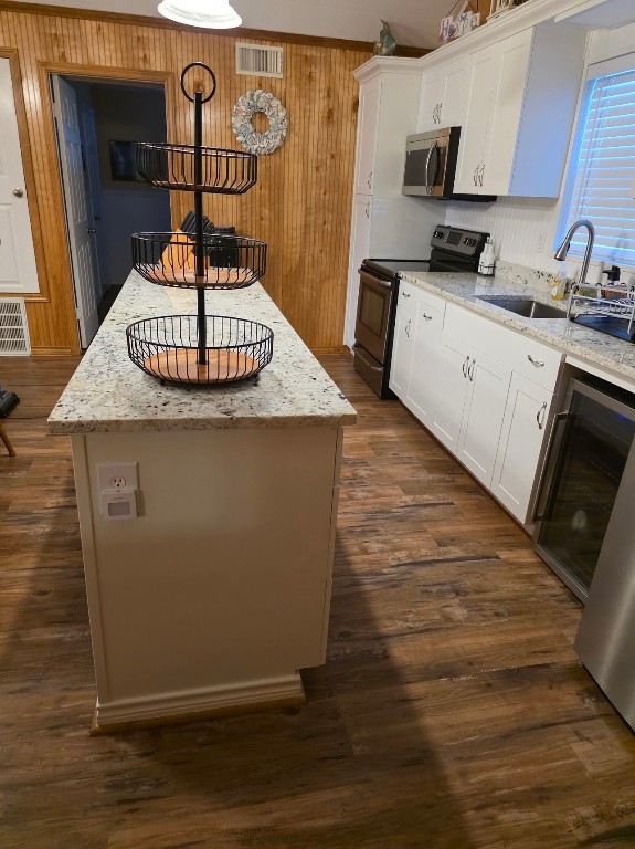 407 Seashell Drive Surfside Beach, TX 77541 - Photo 7 of 18 a kitchen with stainless steel appliances granite countertop a sink dishwasher a stove a refrigerator and microwave with wooden floor