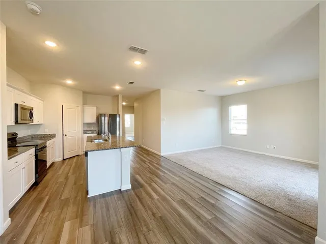 a view of a kitchen with a sink stove top oven and refrigerator