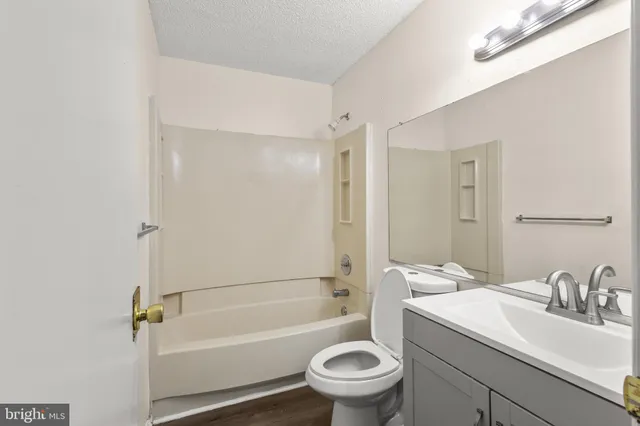 a view of an empty room with glass door and wooden floor