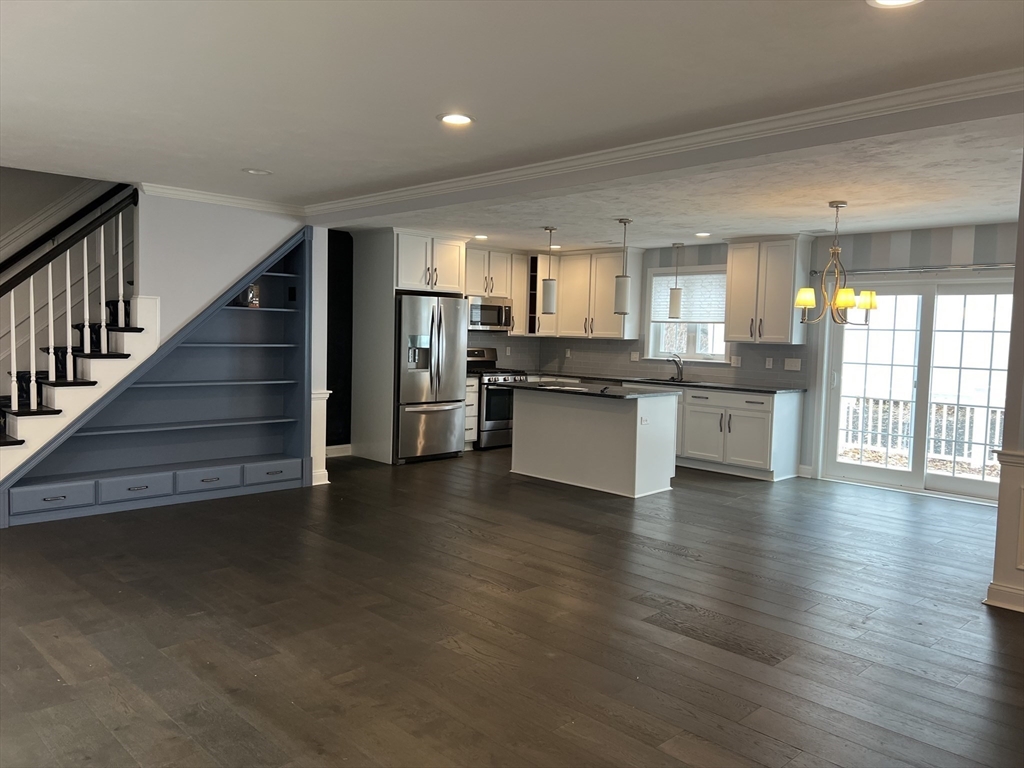 a view of a kitchen with wooden floor and electronic appliances