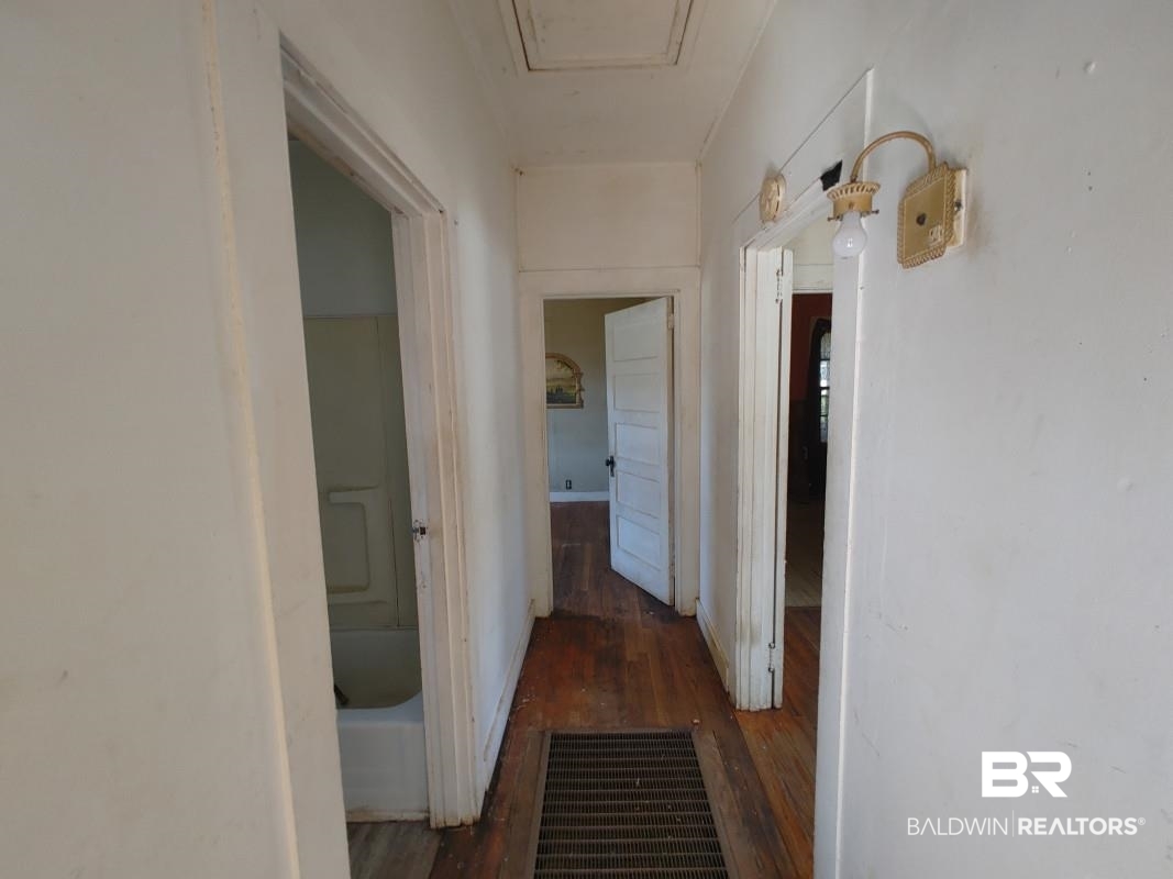 1706 Lomeroy Street Mobile, AL 36604 - Photo 14 of 24 Hall featuring dark wood-style floors, visible vents, and baseboards