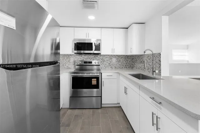 a kitchen with stainless steel appliances a refrigerator sink and microwave