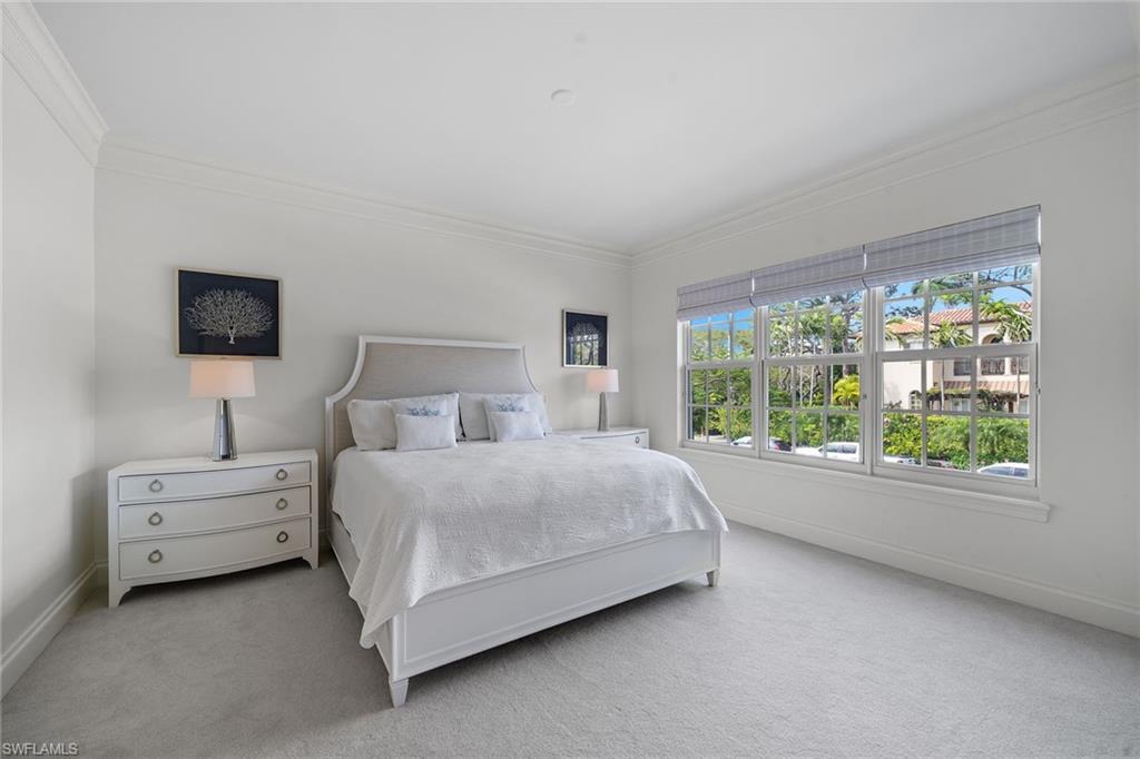 411 6th Street South, Unit 202 Naples, FL 34102 - Photo 13 of 35 a spacious bedroom with a bed and a large window