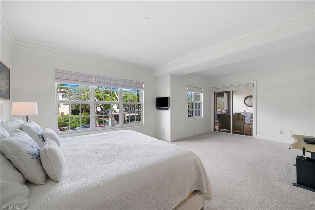 411 6th Street South, Unit 202 Naples, FL 34102 - Photo 14 of 35 a large white bed sitting in a room next to a window