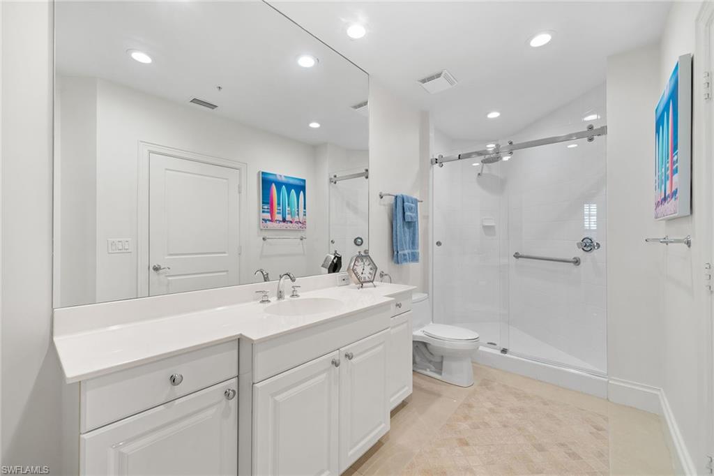 411 6th Street South, Unit 202 Naples, FL 34102 - Photo 20 of 35 a spacious bathroom with a double vanity sink toilet mirror and shower