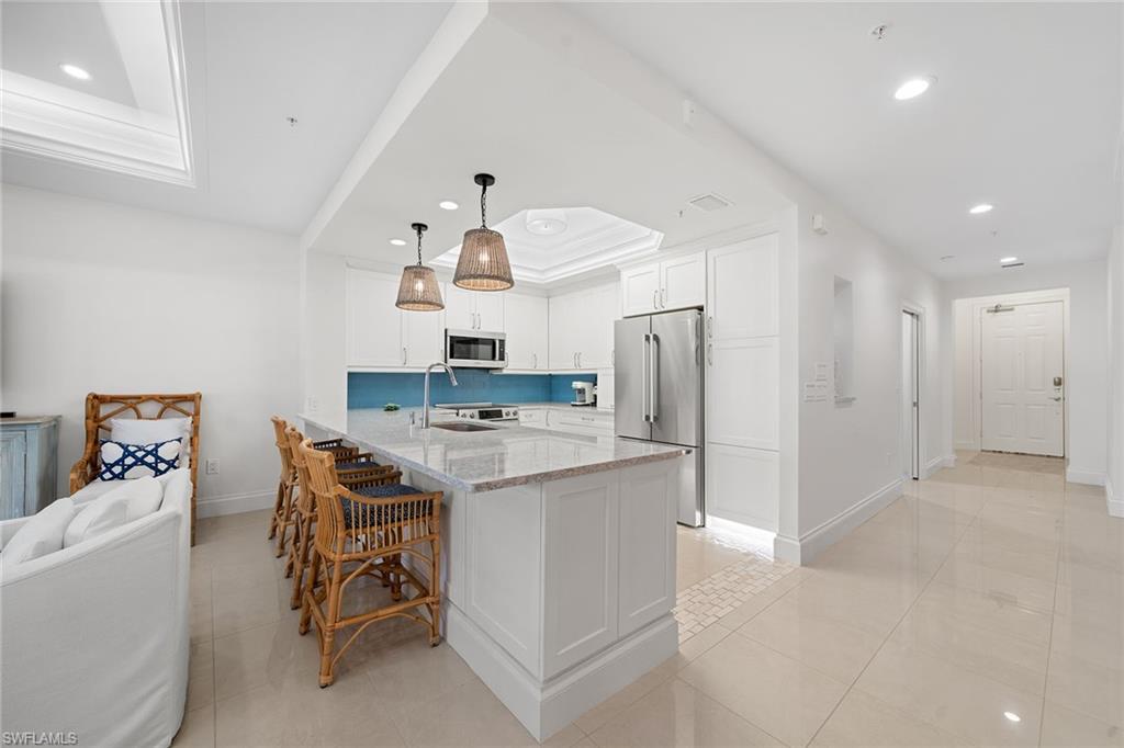 411 6th Street South, Unit 202 Naples, FL 34102 - Photo 7 of 35 a kitchen with a refrigerator and a sink