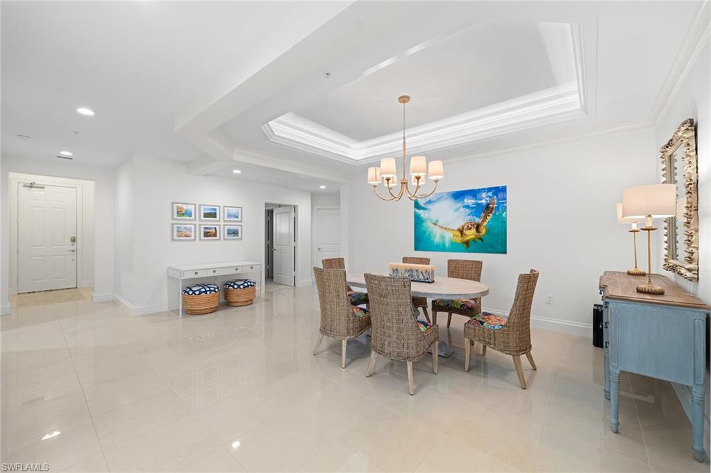 411 6th Street South, Unit 202 Naples, FL 34102 - Photo 8 of 35 a view of a dining room with furniture and chandelier