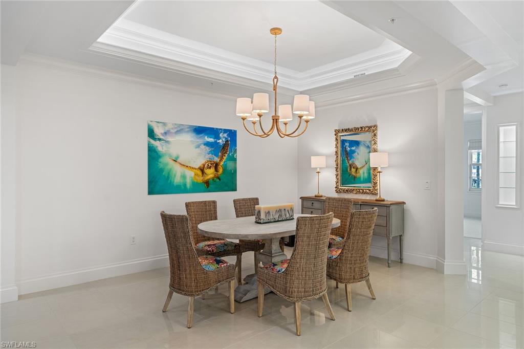 411 6th Street South, Unit 202 Naples, FL 34102 - Photo 9 of 35 a view of a dining room with furniture a chandelier and wooden floor