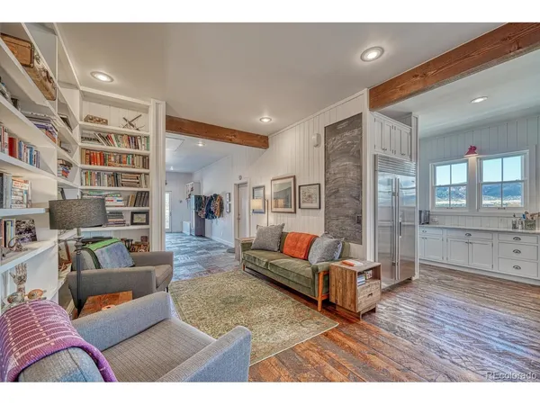 a living room with furniture a chandelier and a dining table