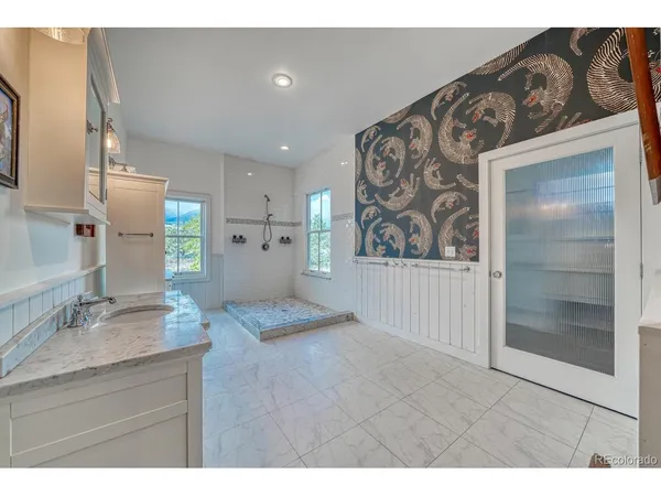 a spacious bedroom with a large bed and a chandelier
