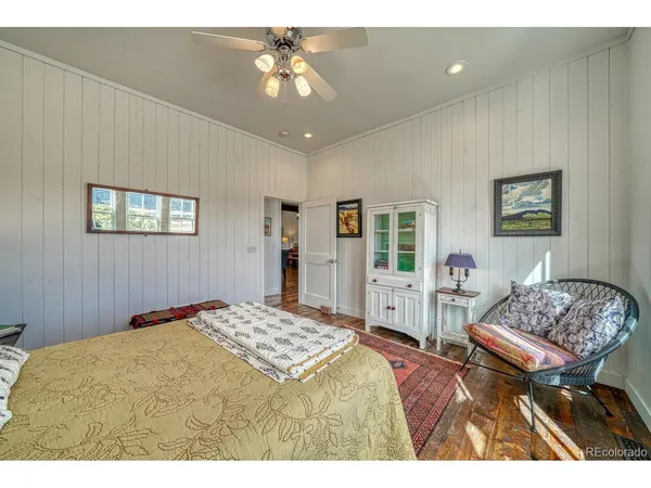 a spacious bedroom with a bed a chandelier and large window