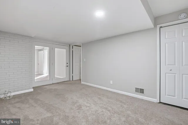 a view of an empty room with wooden floor and a fireplace