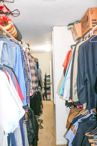 a view of walk in closet with clothes and shoes