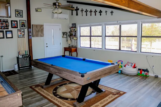 a room with furniture pool table and windows