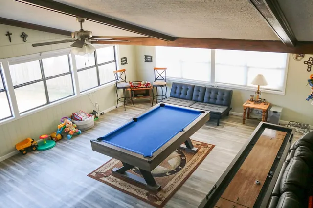 a room with furniture pool table and windows