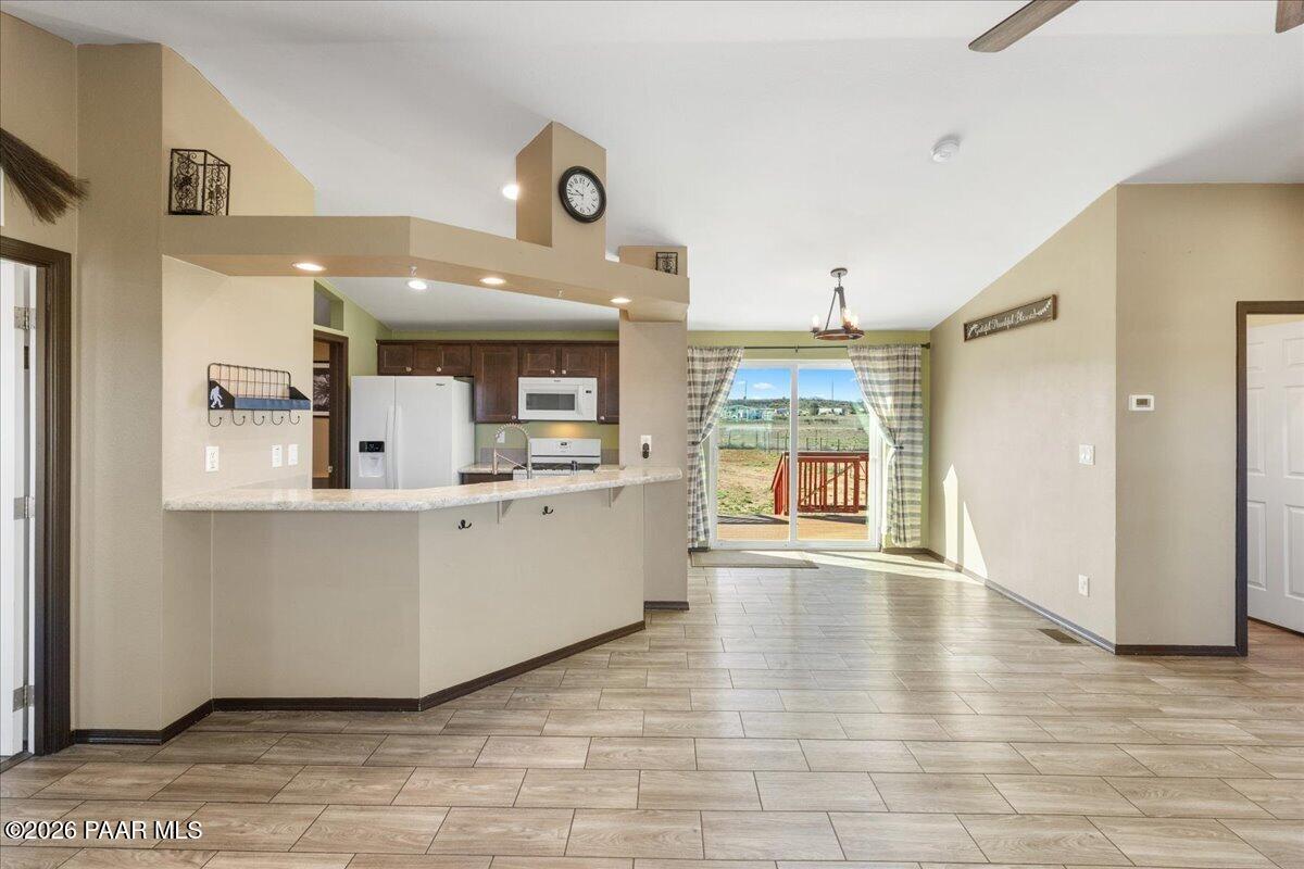 325 East Houston Road Paulden, AZ 86334 - Photo 8 of 40 a large white kitchen with kitchen island a refrigerator a sink dishwasher with a dining table and chairs